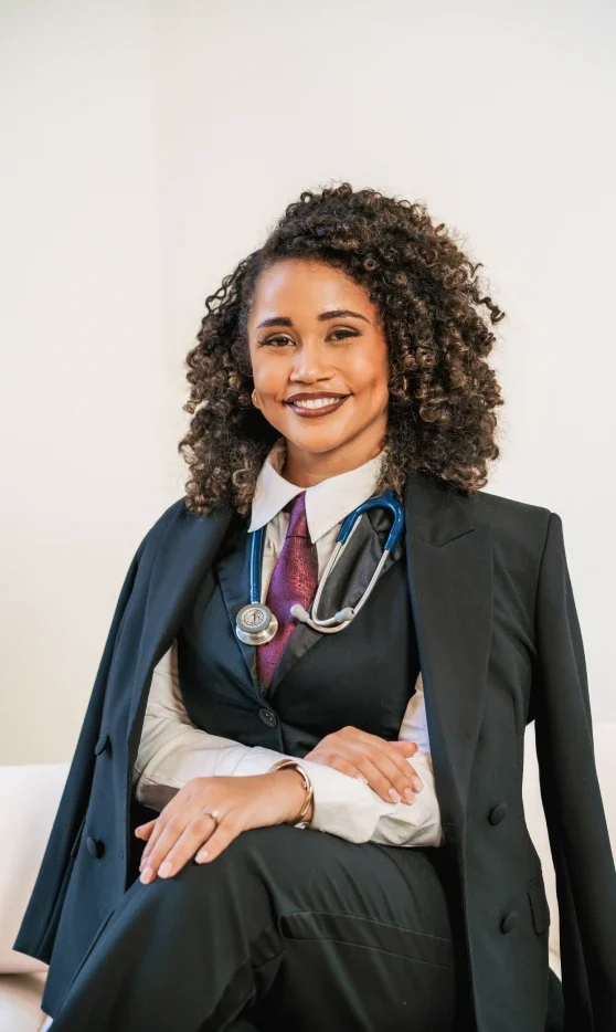 Dr. Taz sitting on a couch with formal attire, smiling